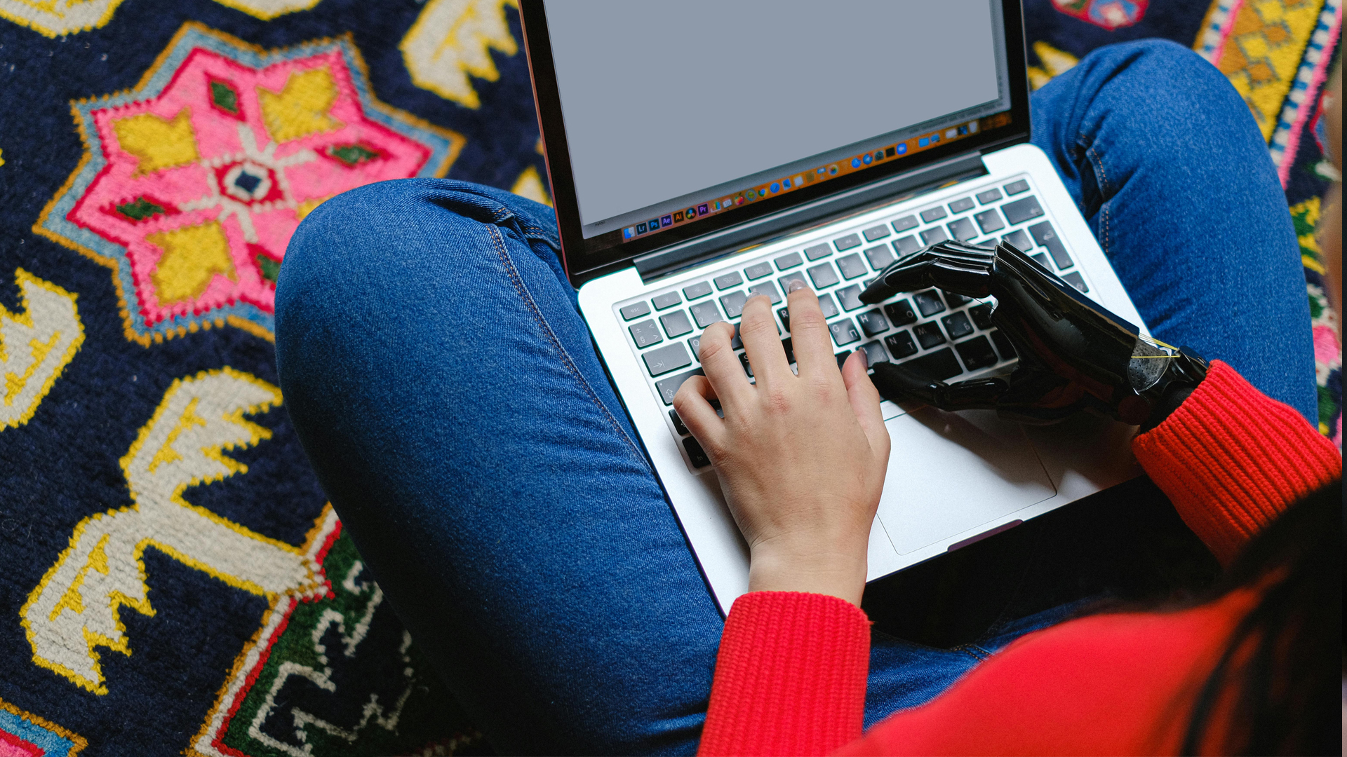 A woman sitting on the floor with a laptop